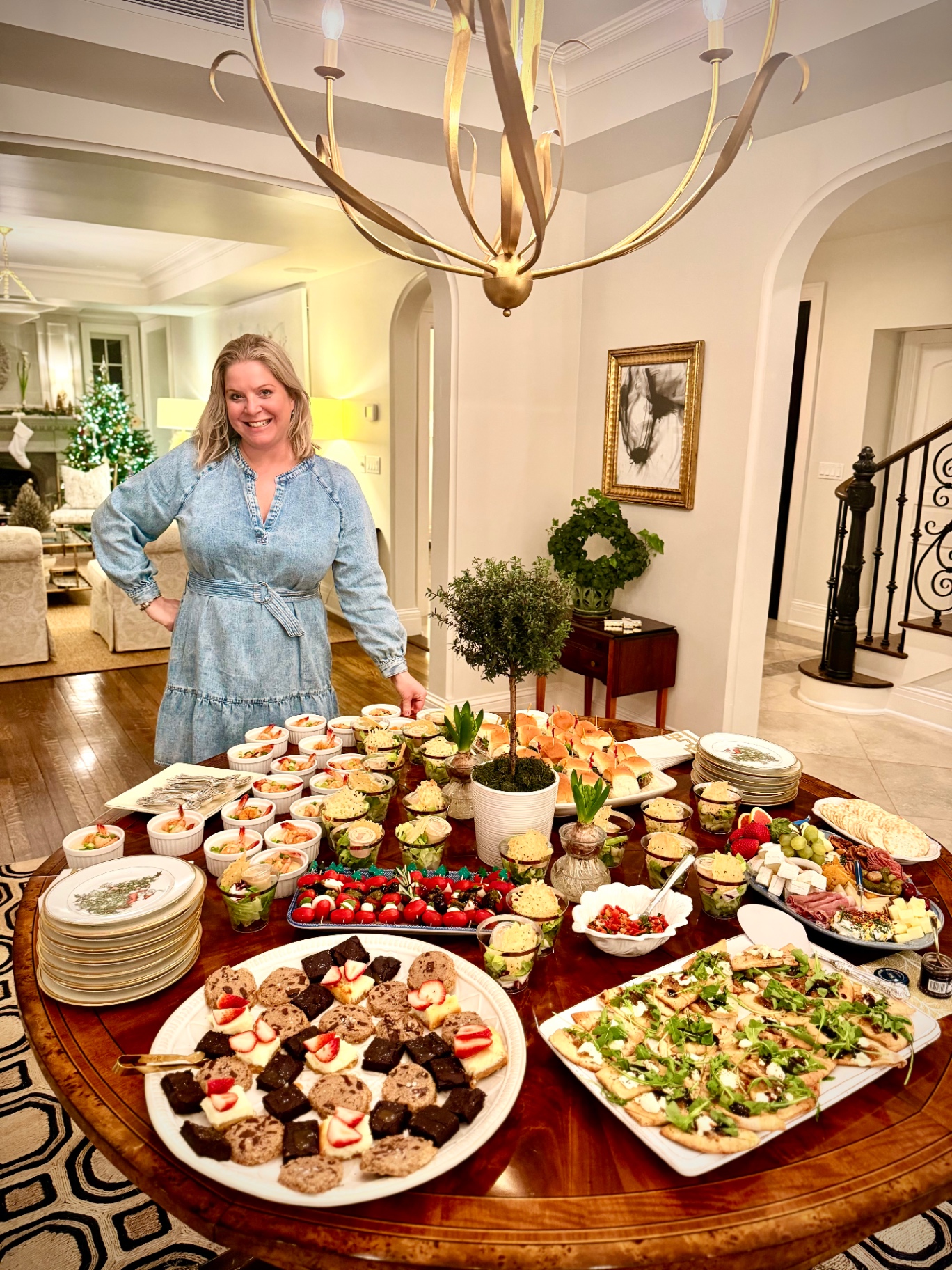 Lauren with a holiday catering spread of shrimp, charcuterie and desserts