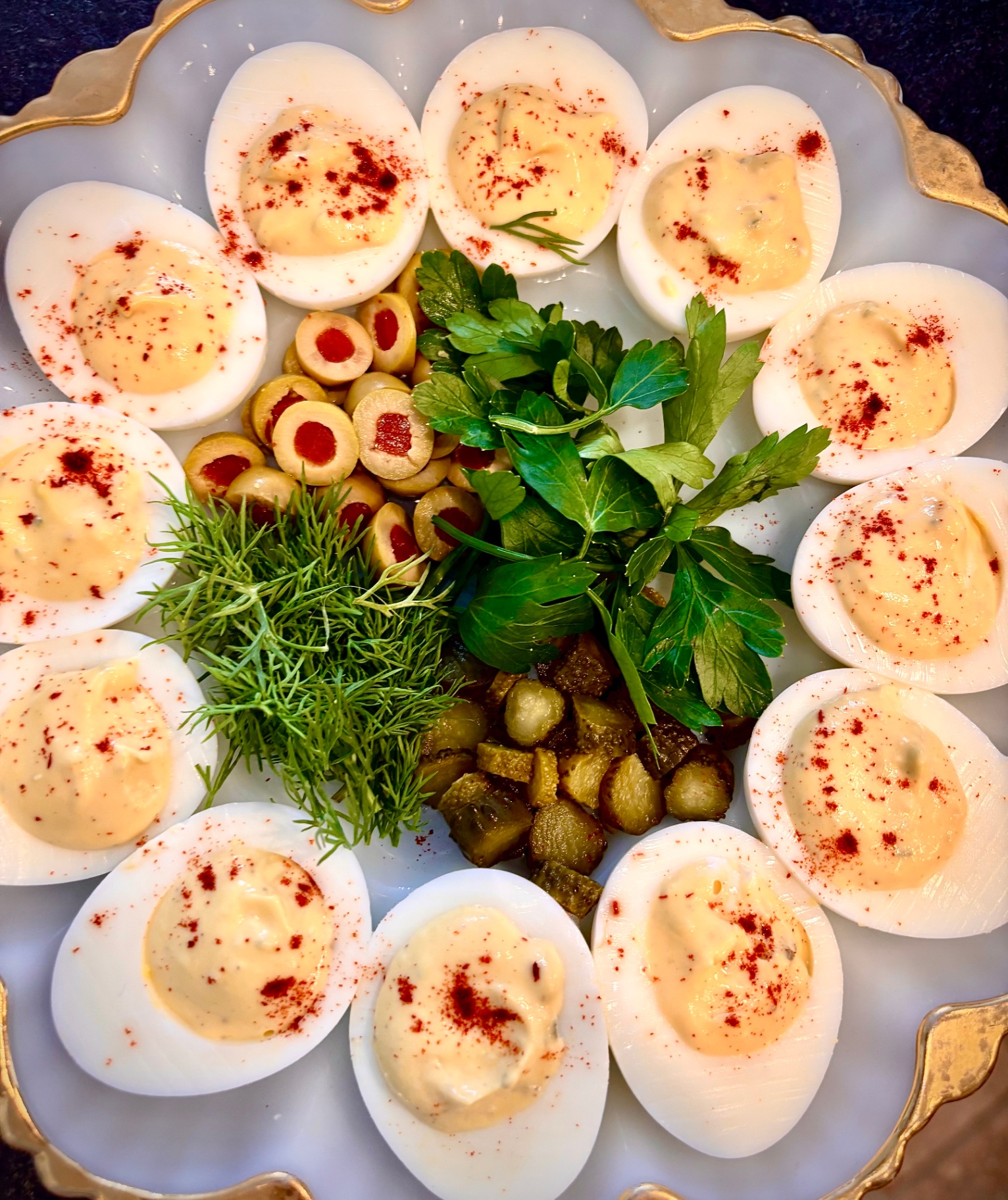 Deviled eggs platter with herbs and olives